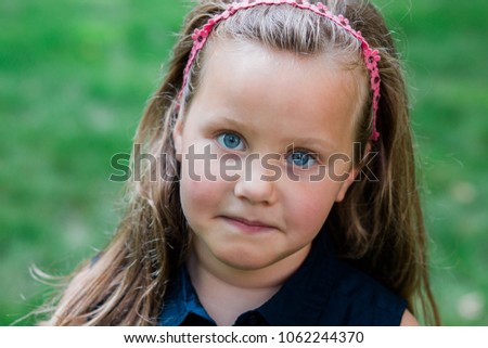 Little girl making faces outside