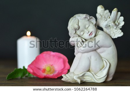 Condolence card. Funeral angel, flower and candle on dark background. 