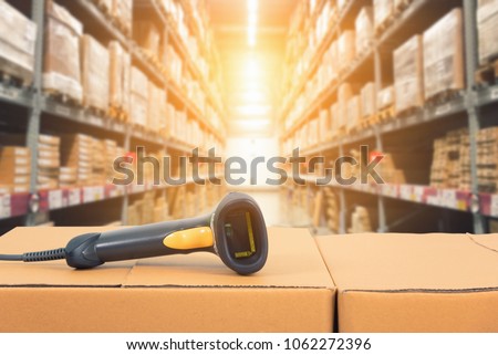 Barcode scanner in front of modern warehouse and scanning code on cardboard box Royalty-Free Stock Photo #1062272396