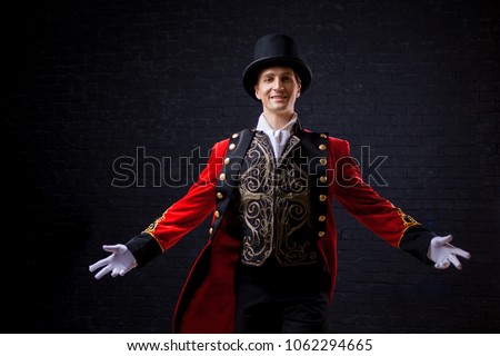 Showman. Young male entertainer, presenter or actor on stage. The guy in the red camisole and the cylinder spreading hands