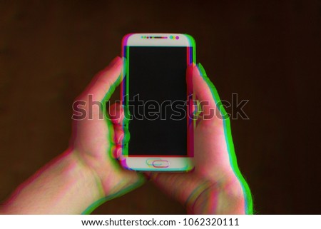 Two hands holding smartphone, mobile phone facing up, closeup. Color channels effect, corrupted image with colorful lines on the phone and hands. Blue, green and red channels.