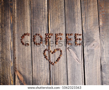 word coffee made from coffee beans on wooden background