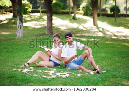 Laughing boy and girl playing tic-tac-toe in the park
