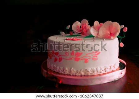 Very beautiful and delicious pink cake with flowers, standing on the table