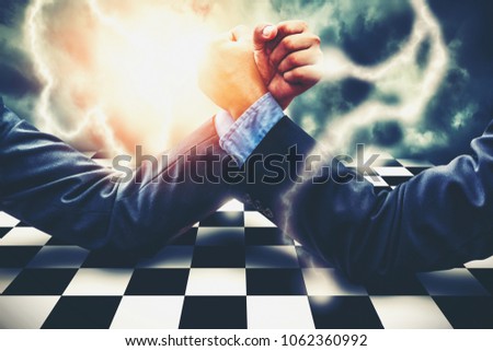 Businessman Competing In Arm Wrestling on lightning storm effect background