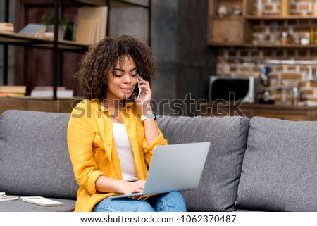 happy woman working and talking by phone at home on couch Royalty-Free Stock Photo #1062370487