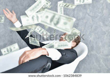 Concept Very wealthy businessman. Businessman is happy with his money. A businessman showing his money.
