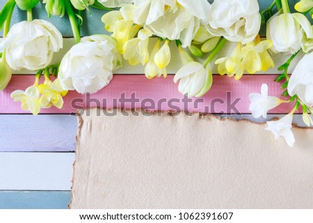 Tulip and freesia flowers on colorful wooden background, copy space. 