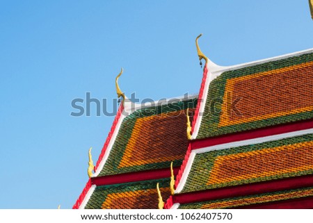 art of Buddhism house of worship temple roof in traditional style by red, orange and green color of tile on top roof and Thai architecture