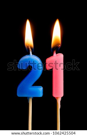 Burning candles in the form of 21 twenty one (numbers, dates) for cake isolated on black background. The concept of celebrating a birthday, anniversary, important date, holiday, table setting