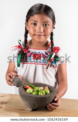 Latin little girl making hot salsa
Shot of cute girl with a mortar and ingredients for salsa