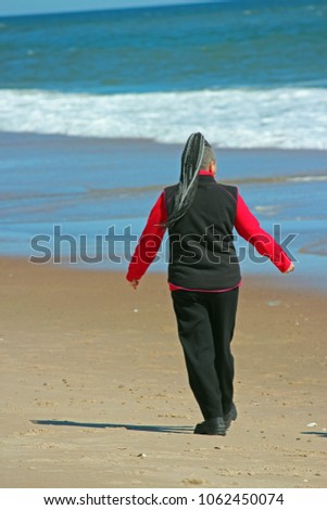 Person walking along the ocean's sandy beach
