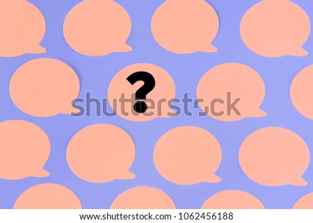 Empty pink stickers on a purple background. In the center one piece of paper with a question mark. An unusual pattern. Beautiful photo from the top.