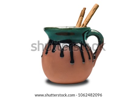 Mexican pot called “Jarrito” used to drink coffee or hot chocolate. Adorned with two sticks of cinnamon Royalty-Free Stock Photo #1062482096