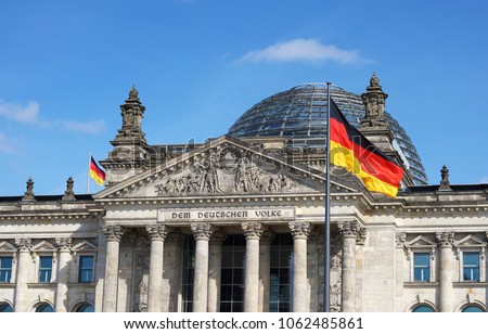 German flag waving at Bundestag building in Berlin Germany front facade view in a sunny day with blue sky. Royalty-Free Stock Photo #1062485861