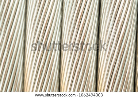 Close up aluminium electricity cable, shiny background. strip texture.