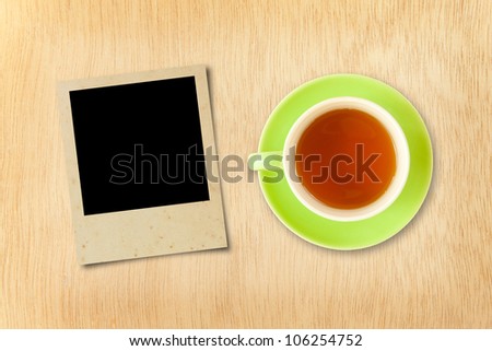 cup tea and photo frame on wood background