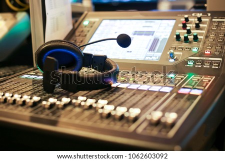 Professional audio Mixer and Professional Headphones in the Recording Studio. Sound Mixing Desk. Sound Mastering For Radio and TV Broadcast.
