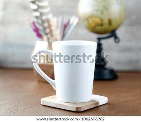 white mug mockup with globe and pens on leather