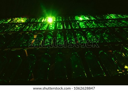 wall of green illuminated bottles in the interior of the bar