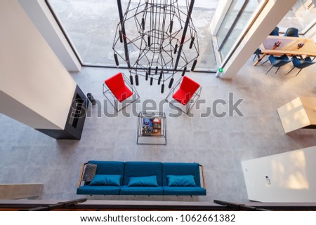 interior of modern living room with large panoramic windows, fireplace and sofa, top view.