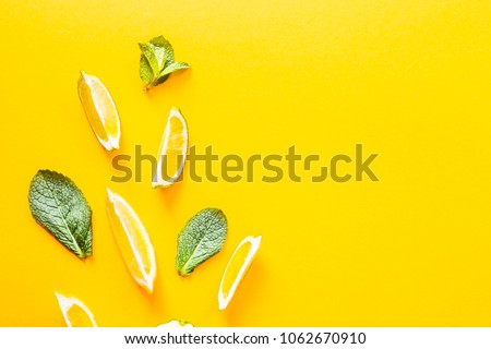 Pieces of lemon, lime and green mint leaves on a yellow background. Summer products for making lemonade. Top view, flat lay, copyspace Royalty-Free Stock Photo #1062670910