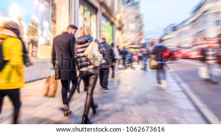 Motion blurred shoppers walking on busy high street Royalty-Free Stock Photo #1062673616
