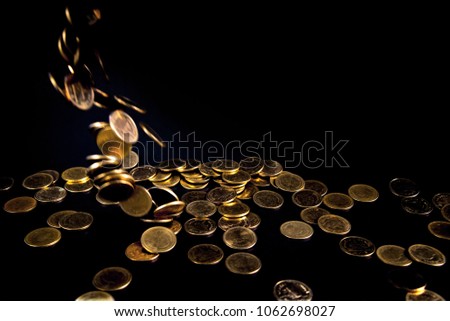 Falling gold coins money in dark background, business concept idea.
