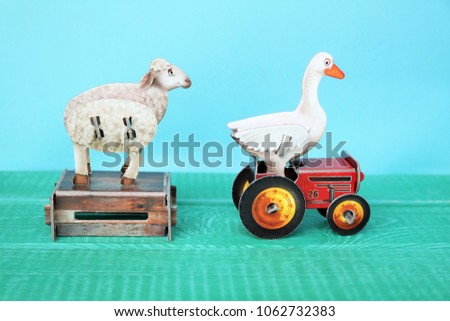 farm animals, sheep and goose. 
small carton figures or childrens toys. 
blue background and copy space.