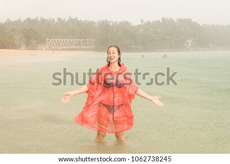 Young women in monsoon rain on the beach