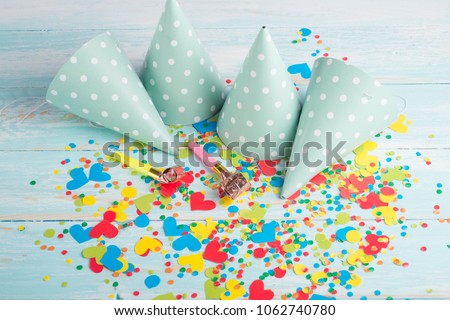 Birthday caps, blowers and confetti on background