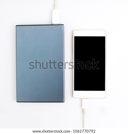 Phone charging with energy bank. Depth of field on Power bank on white background