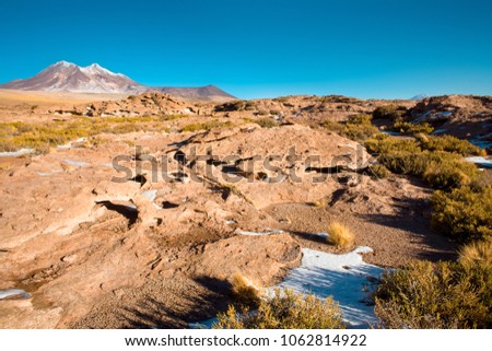 Rock formations of dry lava, with Cerro Miniques (Miniques hill) in the background in the Altiplano (high Andean Plateau), Los Flamencos National Reserve, Atacama desert, Chile, South America 