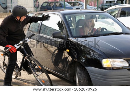 Female car driver puts a cyclist in a dangerous situation near the accident in traffic Royalty-Free Stock Photo #1062870926