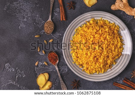 Saffron rice with spices. Top view, copy space. Royalty-Free Stock Photo #1062875108