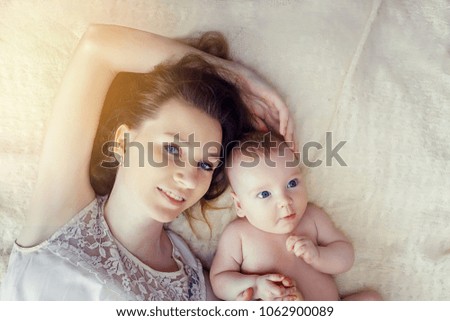 Mother and her child lying in the bed. Sunlight