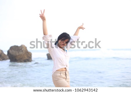 beach girl enjoying at the sea with smilling. Beautiful party girl dancing and waving hands on the beach.