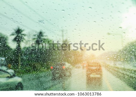 Blurred background with rains drop on glass and cars on the road, There is a traffic jam It's raining. There are a lot of car on the road. This picture was taken in Thailand.