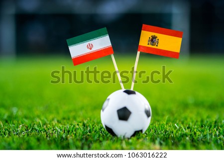 IR Iran - Spain, Group B, Wednesday, 20. June, Football, World Cup, Russia 2018, National Flags on green grass, white football ball on ground. Royalty-Free Stock Photo #1063016222