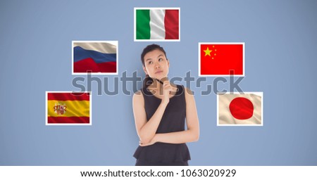 Beautiful woman holding pen and thinking while standing by flags against blue background
