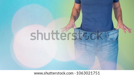 Mid section of man holding loose jeans representing weight loss and standing against abstract backgr