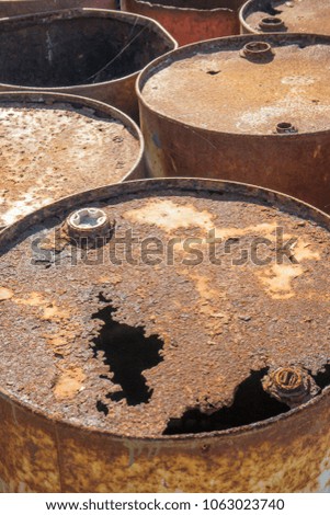 Rusty metal barrels stacked in rows 