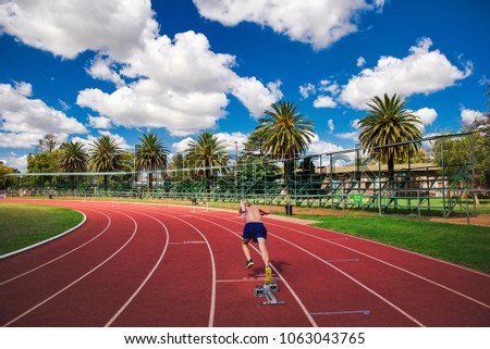 Professional athlete start on tartan track. Track and field professional race. Palms and blue sky in background, sport, running, motivation photo