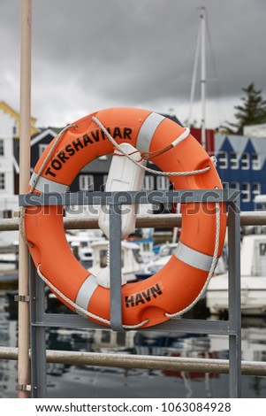 Lifering in port area with name of town of Torshavn, Faroe Islands, Denmark written on it.