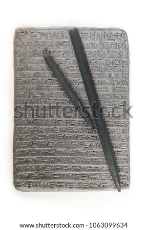 Ancient type of Akkad empire style cuneiform writing in gray clay with tools