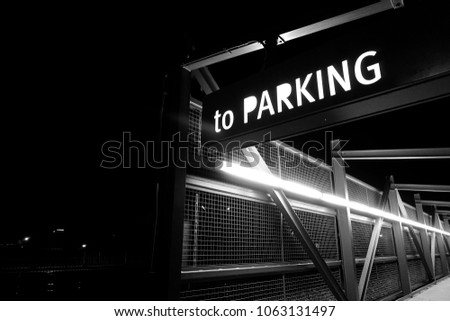  black and white aged and worn photo of parking sign at night                              