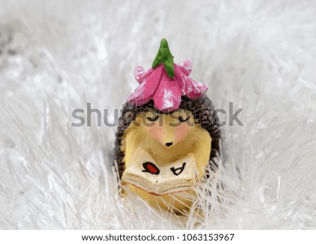 Fairy porcupine with flower hat in snow filled enchanted landscape reading children's book fairy tale