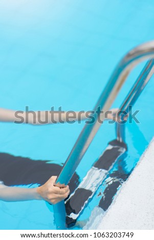Hand woman hold grab bars in swimming pool.