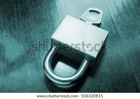 Padlock with key on wooden table