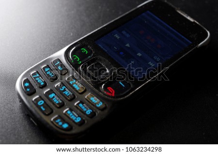 
Mobile phone with luminous keys on a black background